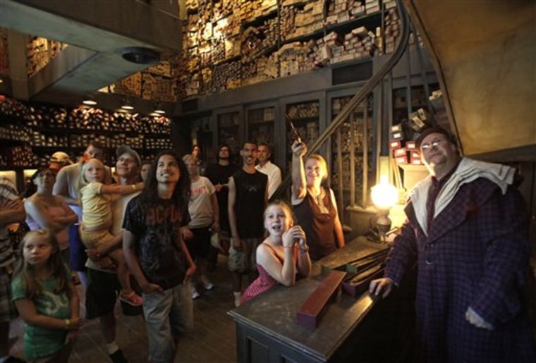 A clerk, right, at Ollivander's Wand Shop helps visitors pick out a magic wand June 9 at The Wizarding World of Harry Potter at Universal Orlando in Orlando, Fla. In the quarter after the attraction opened, crowds at Universal parks swelled by 36 percent over the same stretch last year, while attendance at Disney's Orlando parks stayed roughly the same.